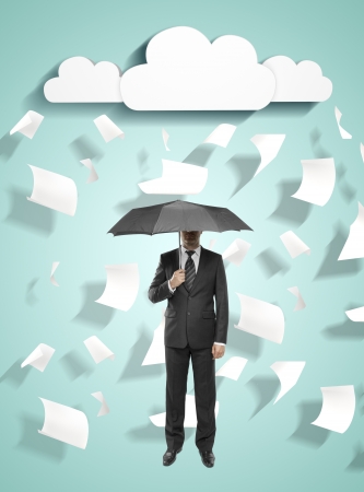 businessman standing with umbrella with flying around paperの写真素材