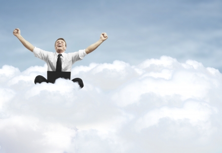 businessman with laptop sitting on cloudの写真素材