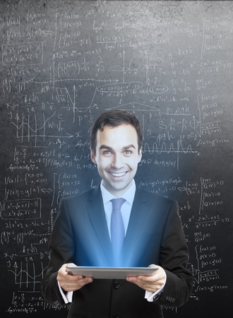 businessman holding tablet with interface and drawing formulaの写真素材