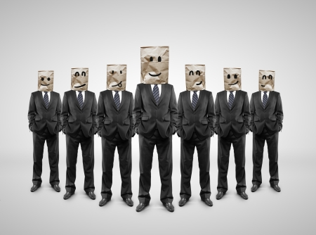 several businessman standing with paper bag on headの写真素材