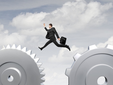 man jumping from one gear to anotherの写真素材