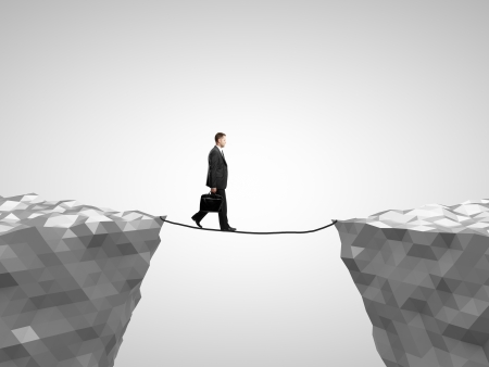 businessman walking on rope from mountain to mountainの写真素材