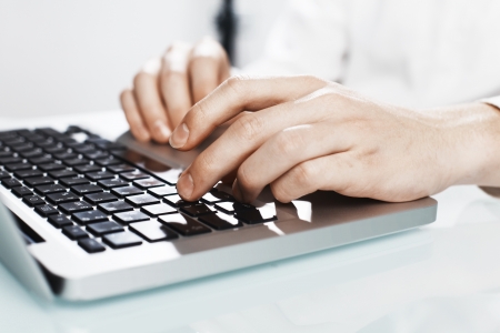 human hands pushing keys of laptopの写真素材