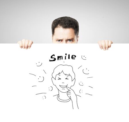 businessman holding placard with drawing smile conceptの写真素材