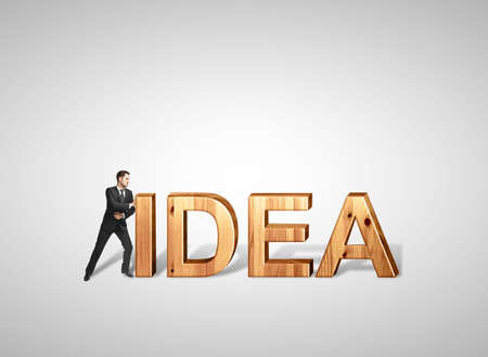 young businessman pushing wooden text ideaの写真素材
