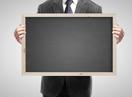 businessman in suit holding blank blackboardの写真素材