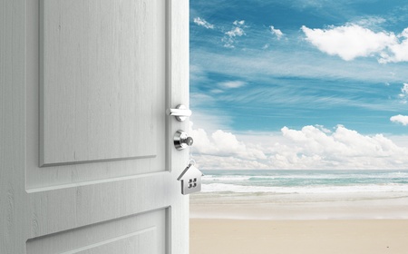 opened door with key in lock in beachの写真素材