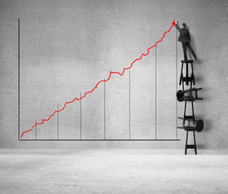 man standing on stool and drawing graphの写真素材