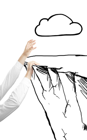 hand climbing the mountain with drawing cloudの写真素材