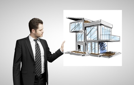 businessman holding poster with modern houseの写真素材