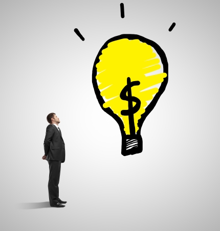 businessman looking at drawing lamp on a gray backgroundの写真素材