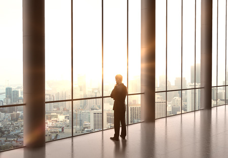 businessman thinking and standing in officeの写真素材