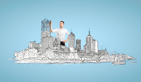 businessman drawing abstract city on blue backgroundの写真素材