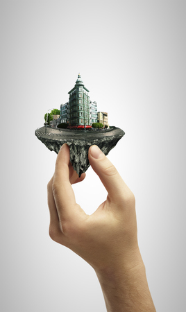 hand holding island in sky with downtownの写真素材