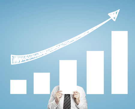 businessman holding chart on a blue backgroundの写真素材