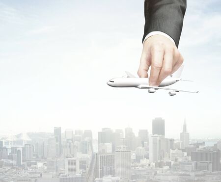 hand holding plane on city backgroundの写真素材