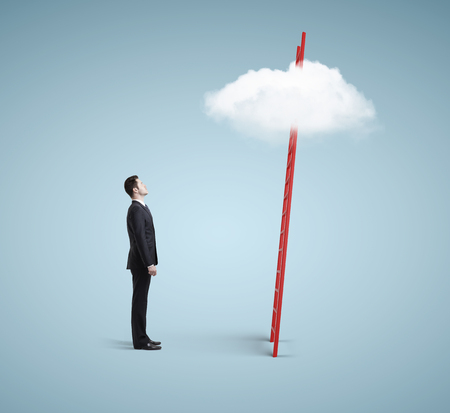 young man  looking on ladder with cloudの写真素材