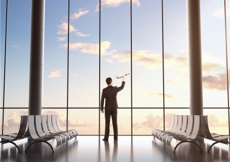 businessman holding plane in airport terminalの写真素材
