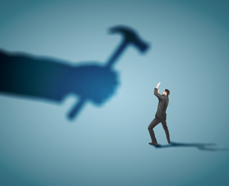 businessman fears shadow hammer blowの写真素材