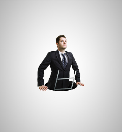 Businessman climbs out of the holeの写真素材