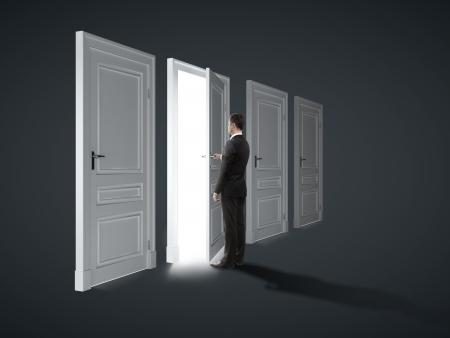 three closed doors and one opened by businessmanの写真素材