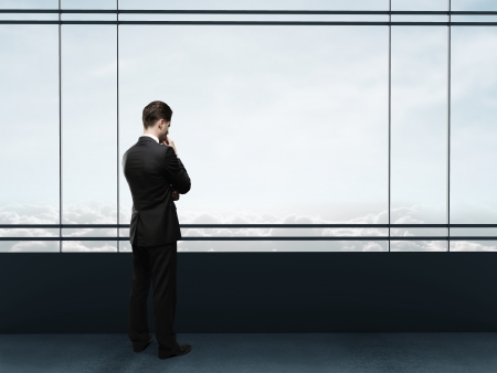businessman thinking in office and looking to windowの写真素材