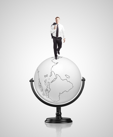 happy businessman walking on concrete globeの写真素材