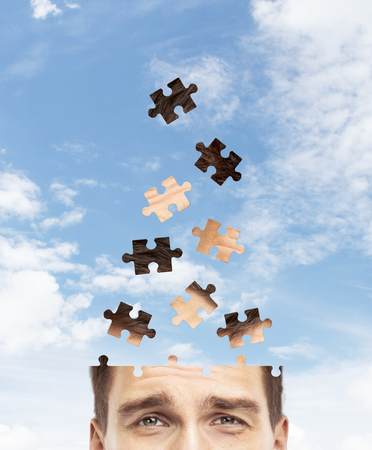 head man built of puzzle on sky backgroundの写真素材