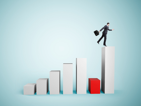 businessman jumping on big graph   on blue backgroundの写真素材