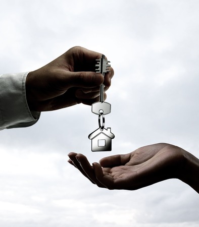 Man is handing a house key to a womanの写真素材