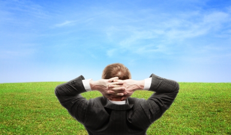businessman sitting and looking at fieldの写真素材