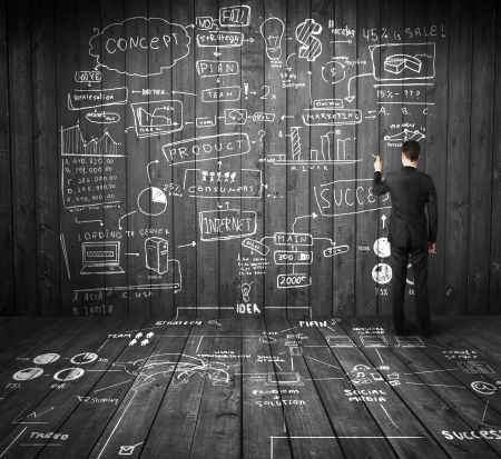businessman drawing business plan on wooden wallの写真素材
