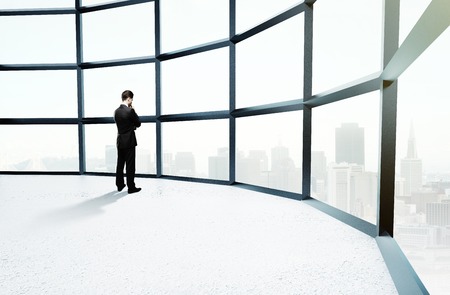 businessman thinking  in big white officeの写真素材