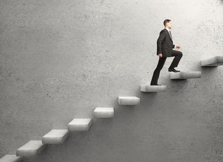 businessman walking on concrete ladder