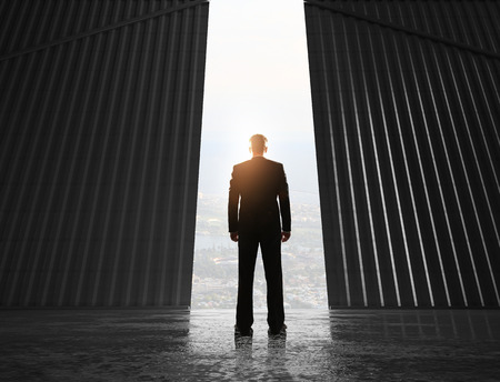 businessman looking to open doors to hangarの写真素材