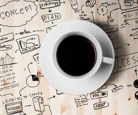 coffee cup and drawing business strategy on a white background