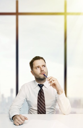 busienssman sitting in office and thinkingの写真素材