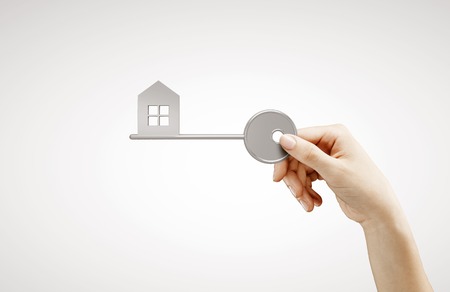 hand holding key house on white backgroundの写真素材