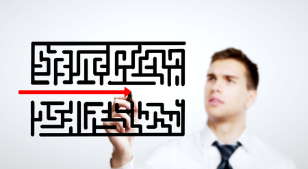 businessman drawing labyrinth on a white backgroundの写真素材