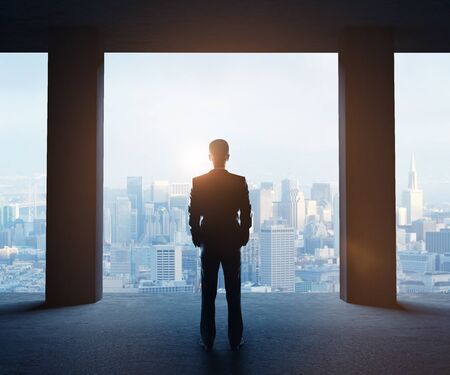 businessman in office looking to cityの写真素材