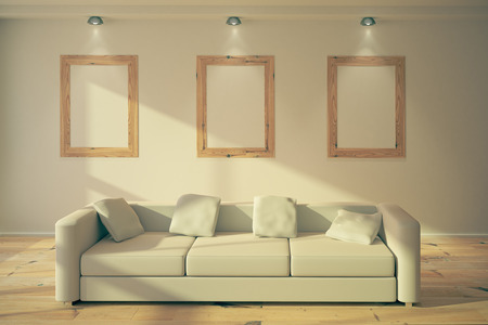 Three blank wooden frames hanging on the wall in loft interior room above sofa with pillows. Mock up, 3D Renderの写真素材