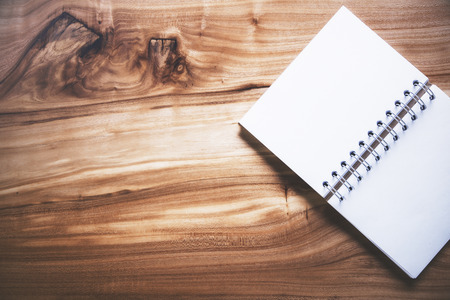 Topview of wooden table with blank notepad on the right side. Mock upの写真素材