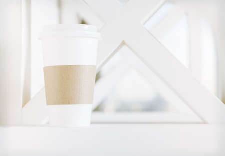Plastic coffee cup on blurry window backgroundの写真素材