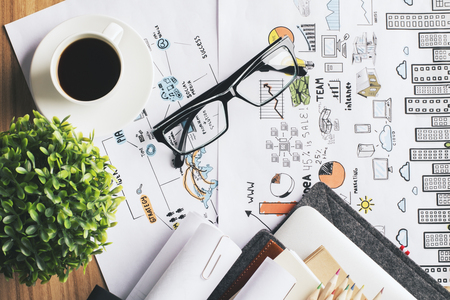 Topview of desk with coffee, glasses and plant on business concept sketch