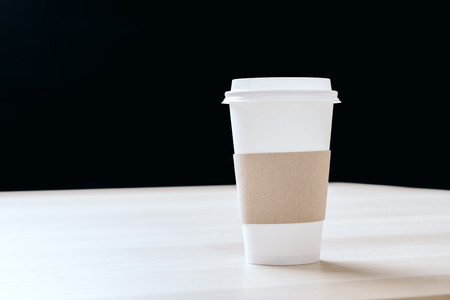 Plastic coffee cup on wooden table and black background. Mock upの写真素材