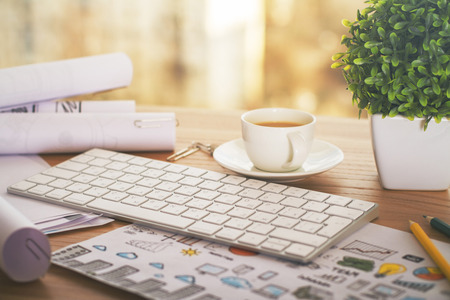 Desktop with coffee cup, keypad business concept sketch and other items
