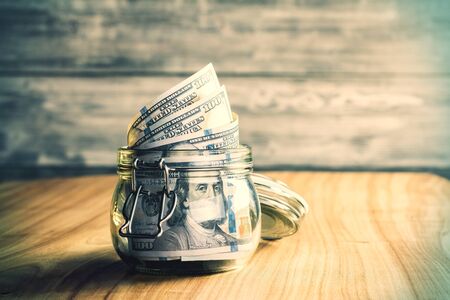 Jar with dollar bills on wooden desktopの写真素材