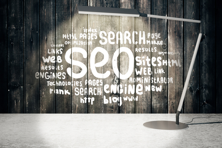 Lamp illuminating SEO sketch on wooden wall. 3D Renderingの写真素材