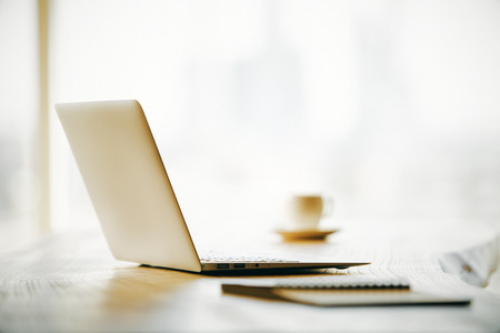Sideview of laptop on desktop with other blurry itemsの写真素材
