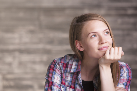 Portrait of thoughtful smiling young woman in casual shirtの写真素材
